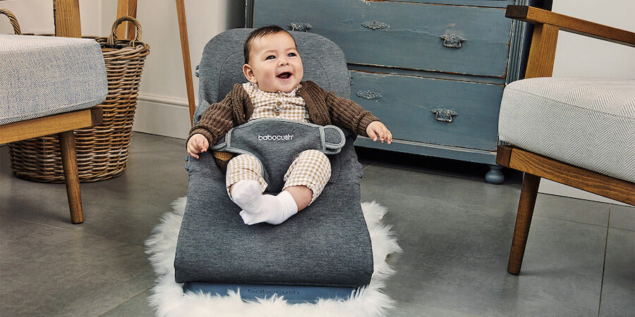 Baby sitting on Babocush baby bouncer and toddler chair