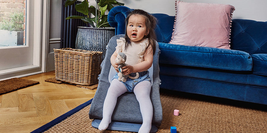 Toddler sitting on Babocush baby bouncer converted into chair